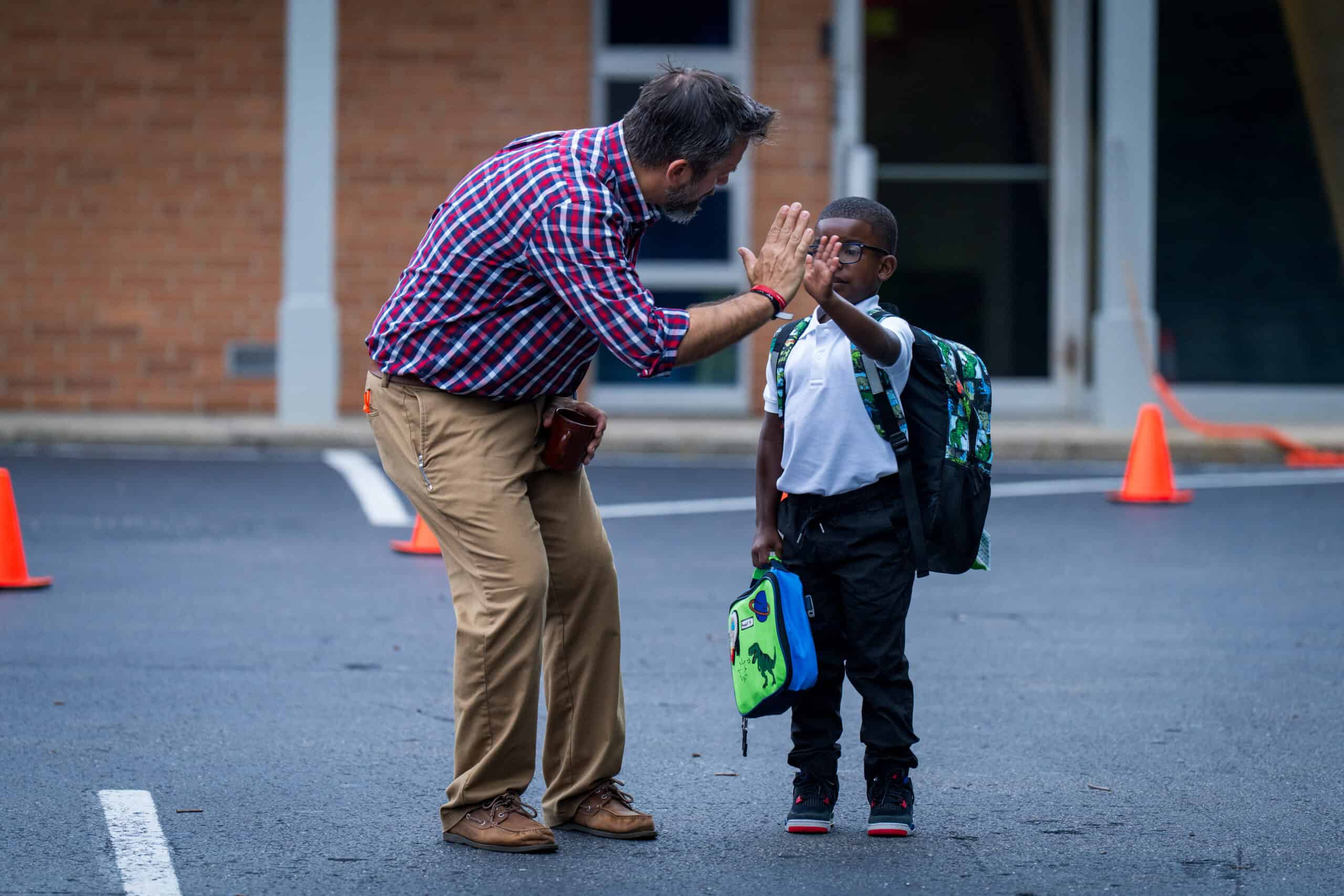 Teacher greeting student at morning drop-off